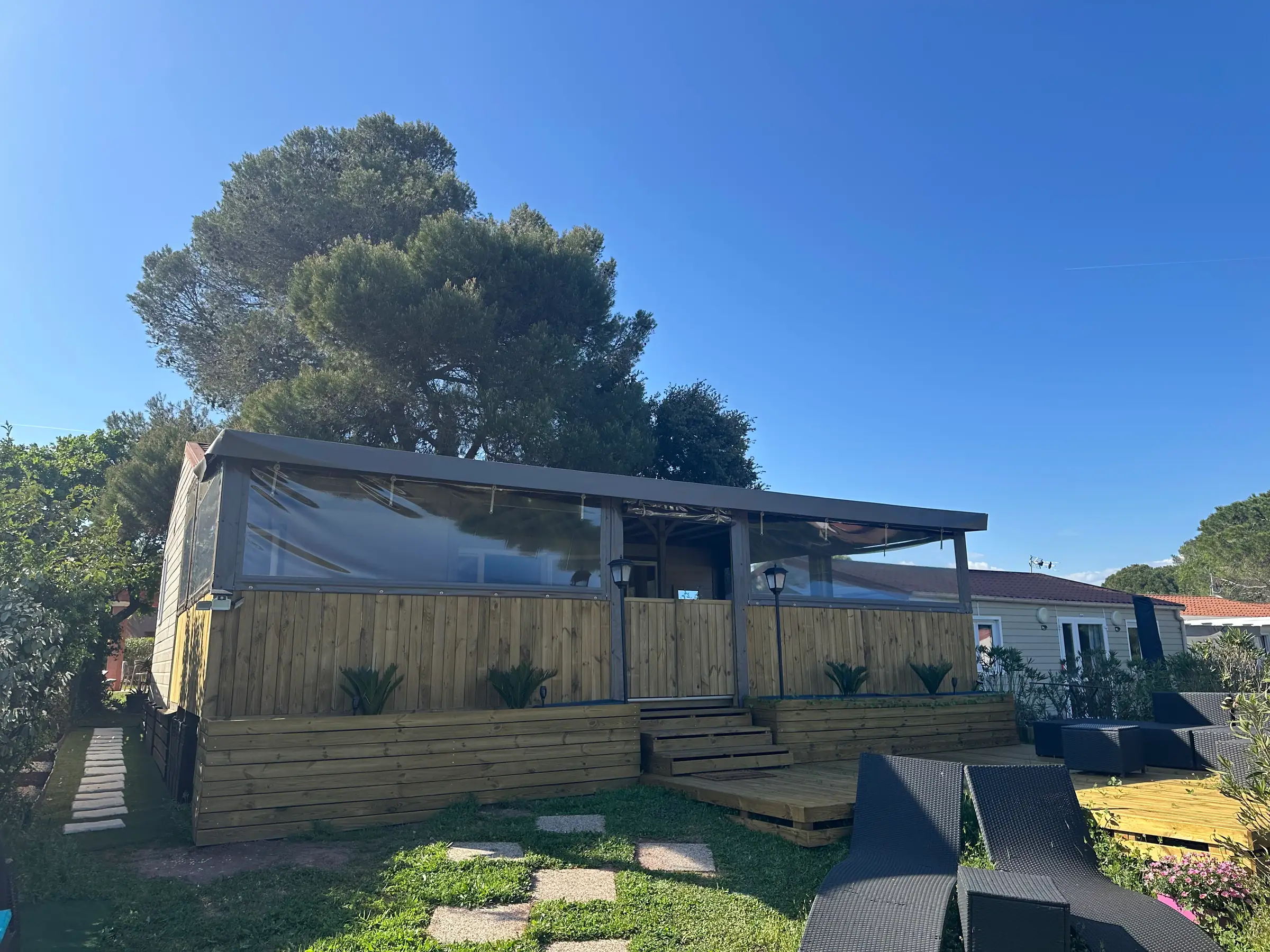 Le chalet et son bardage bois vus depuis le fond du jardin