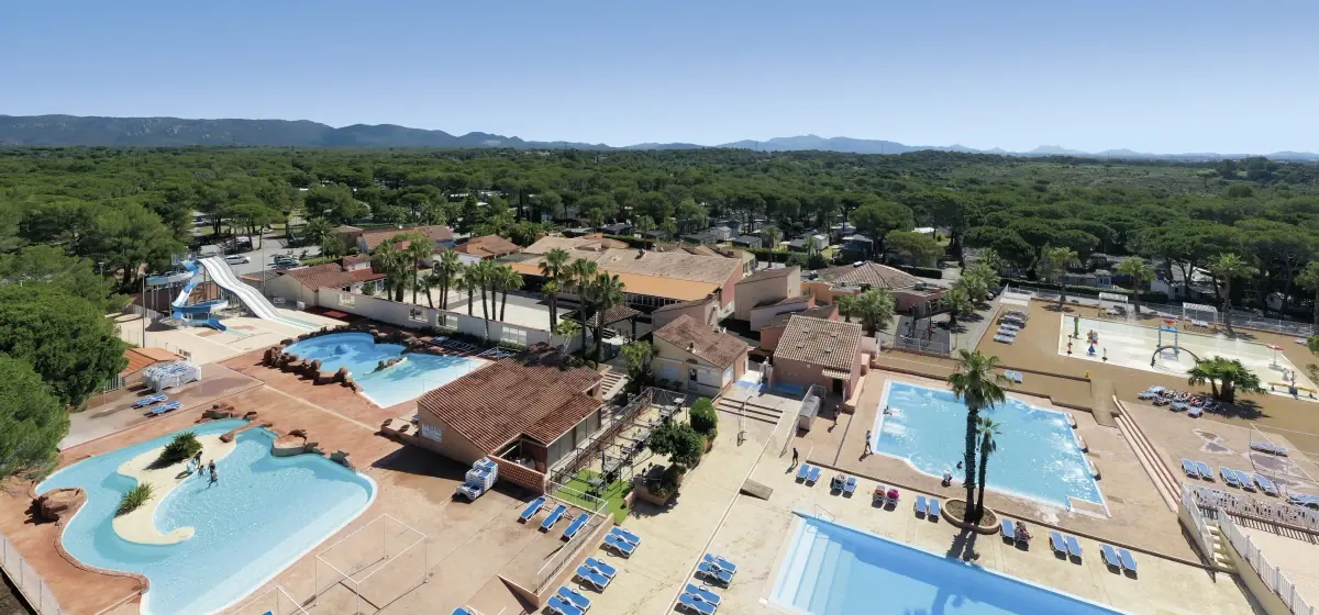 Vue aérienne du domaine, ses bassins et sa pinède, collines du Var à l'horizon