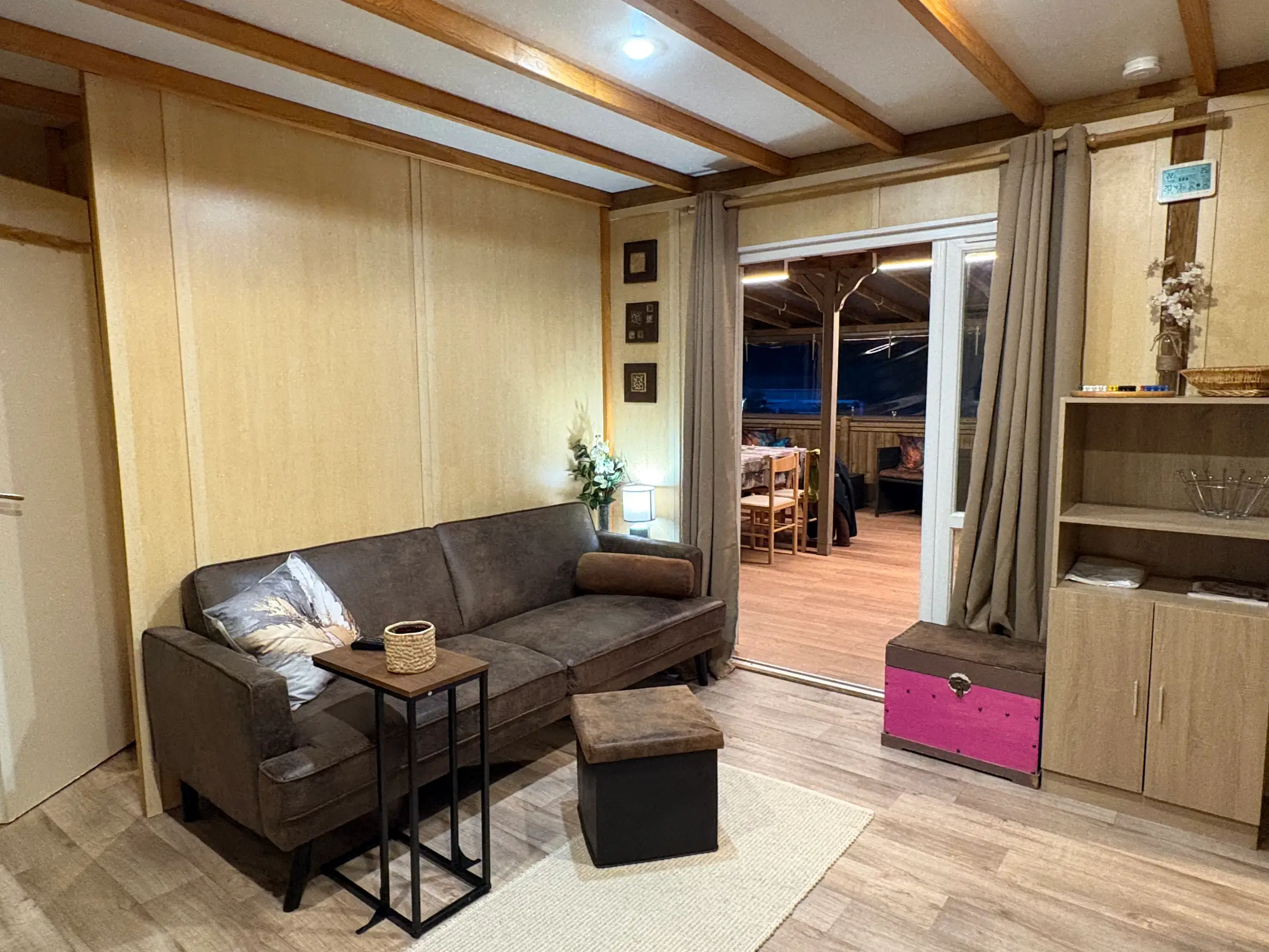 Salon intérieur avec canapé en cuir vieilli et baie ouverte sur la terrasse